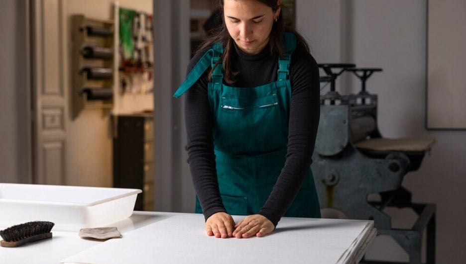 Técnicas de impresion, mujer preparando papel para hacer impresion tradicional en prensa